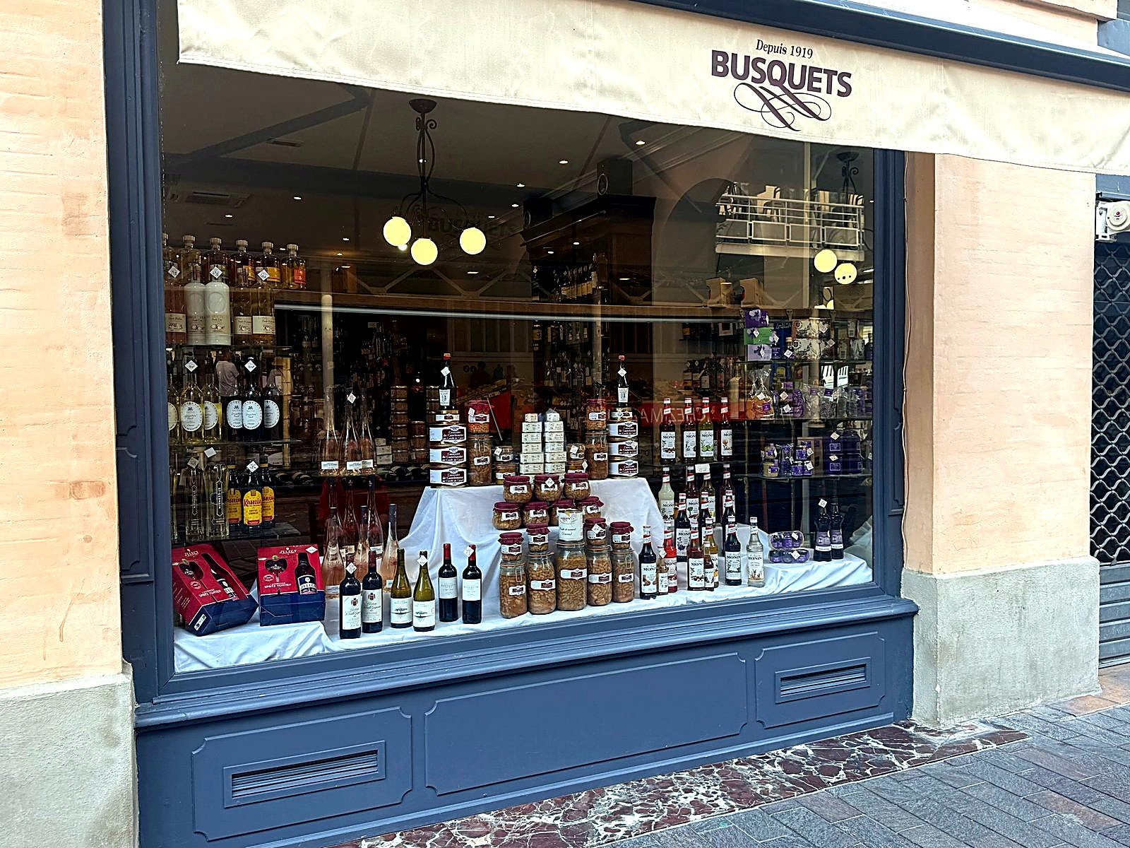 Vitrine extérieure de la boutique Maison Busquets place Victor Hugo, spiritueux et coffrets cadeaux