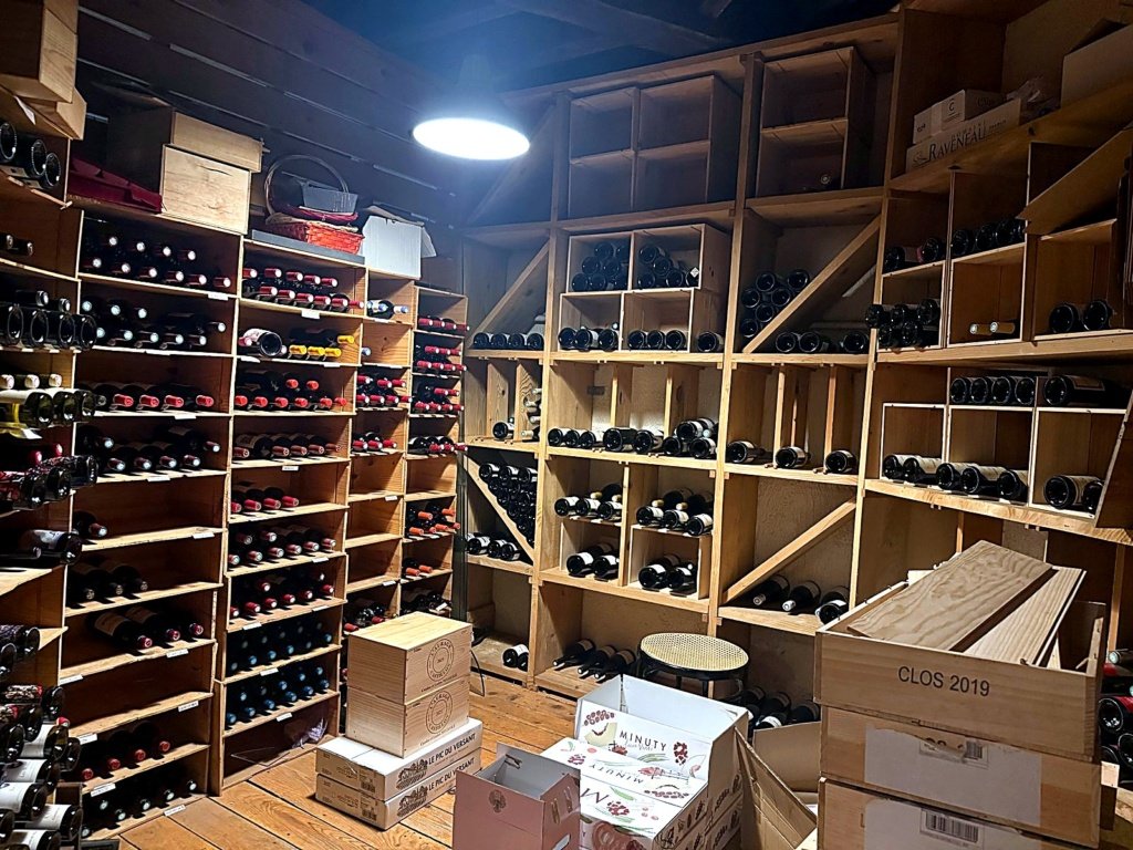 Cave de stockage avec bouteilles de vin rangées en casiers bois, Maison Busquets