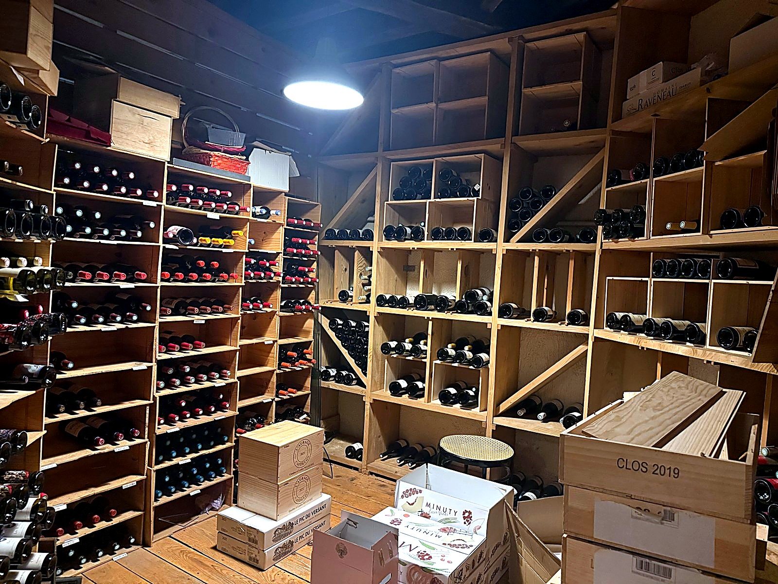 Cave de stockage avec bouteilles de vin rangées en casiers bois, Maison Busquets