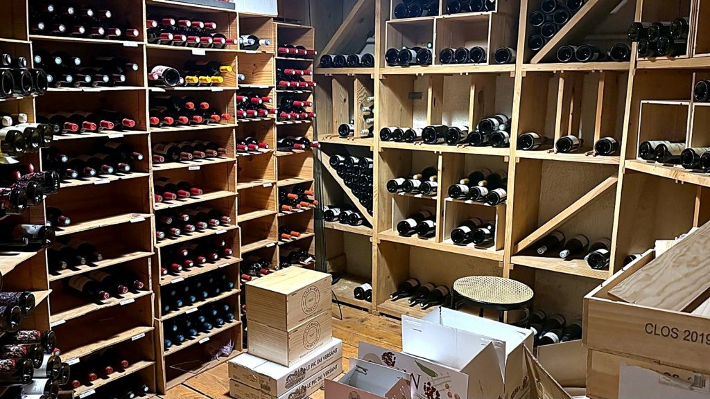 Réserve de la cave Maison Busquets à Toulouse, casiers en bois et caisses de vin