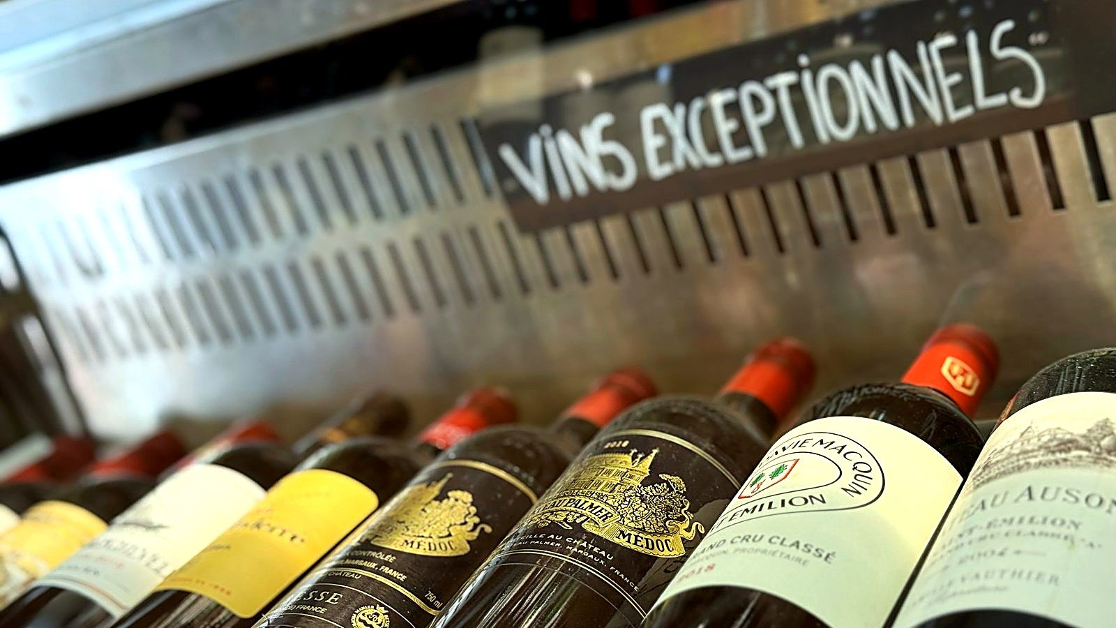 Rayon des grands vins de la cave à vin Busquets à Toulouse, bouteilles couchées sous l'étiquette du rayon