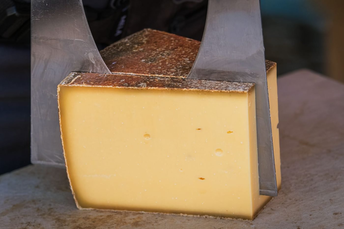 Meule de fromage à pâte pressée cuite tranchée au fil