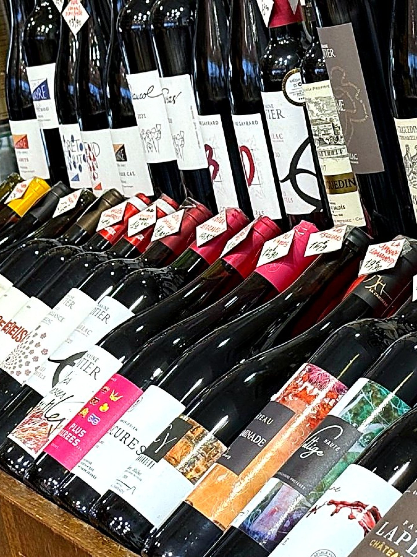 Présentoir de vins aux étiquettes colorées dans la cave à vin Maison Busquets à Toulouse